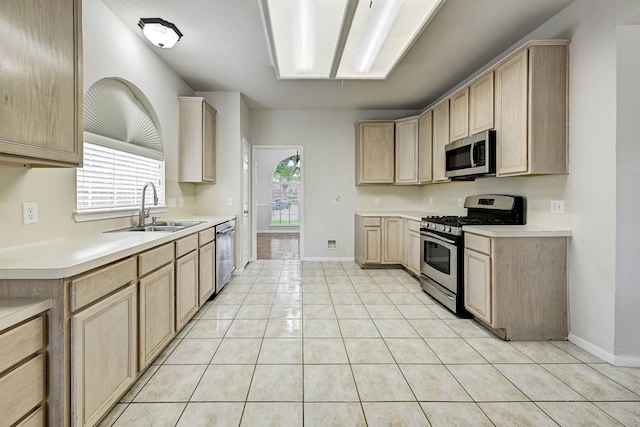 kitchen with a wealth of natural light, light brown cabinets, sink, and appliances with stainless steel finishes