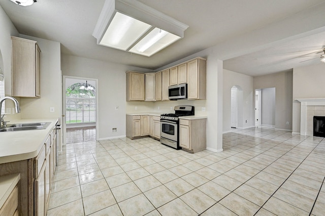 kitchen with appliances with stainless steel finishes, ceiling fan, light brown cabinetry, and sink