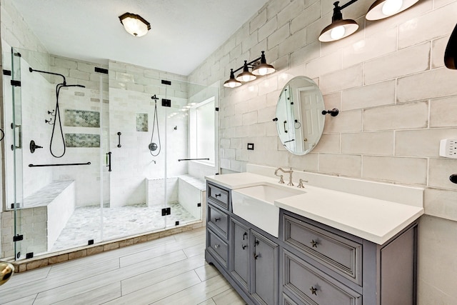 bathroom with vanity, walk in shower, and tile walls