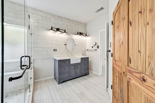 bathroom with vanity and a shower with shower door