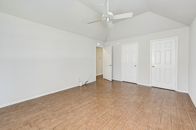 unfurnished bedroom featuring multiple closets, ceiling fan, lofted ceiling, and hardwood / wood-style flooring