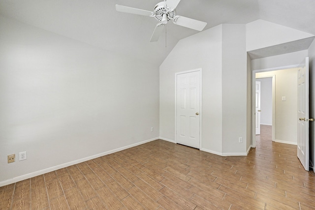 unfurnished bedroom with ceiling fan, a closet, vaulted ceiling, and light wood-type flooring