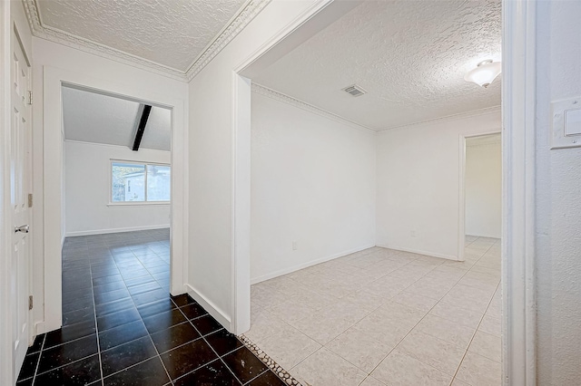 spare room featuring beam ceiling, tile patterned flooring, and a textured ceiling