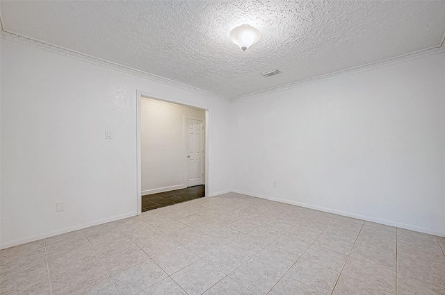 tiled spare room featuring a textured ceiling and ornamental molding