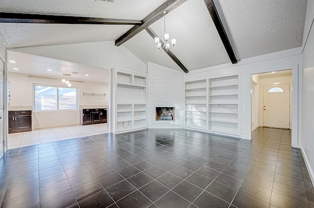 unfurnished living room with lofted ceiling, built in shelves, a fireplace, a textured ceiling, and a notable chandelier