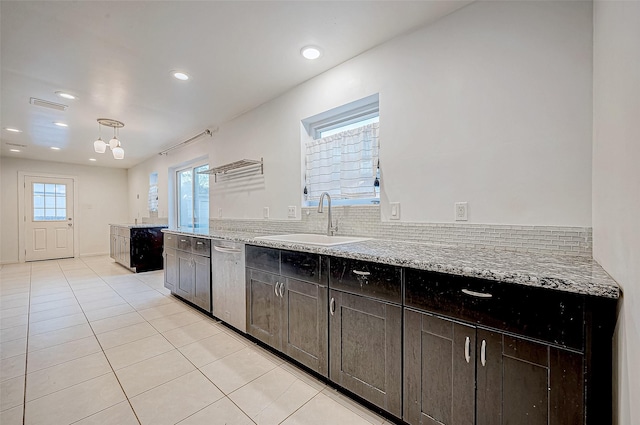 kitchen with dishwasher, dark brown cabinetry, light stone counters, and sink