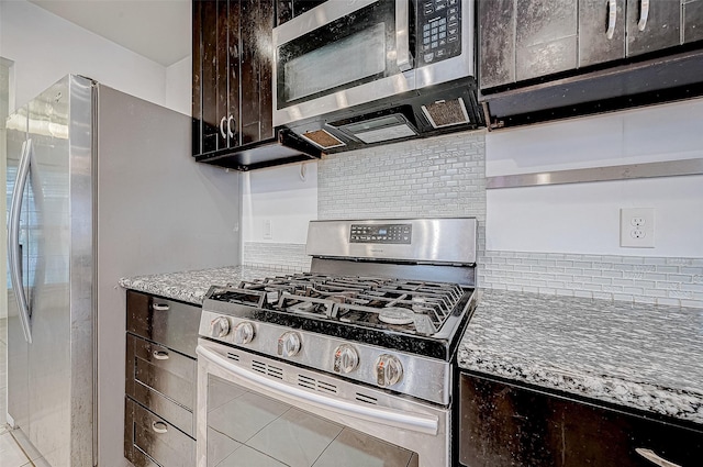 kitchen with light stone countertops, dark brown cabinetry, and appliances with stainless steel finishes