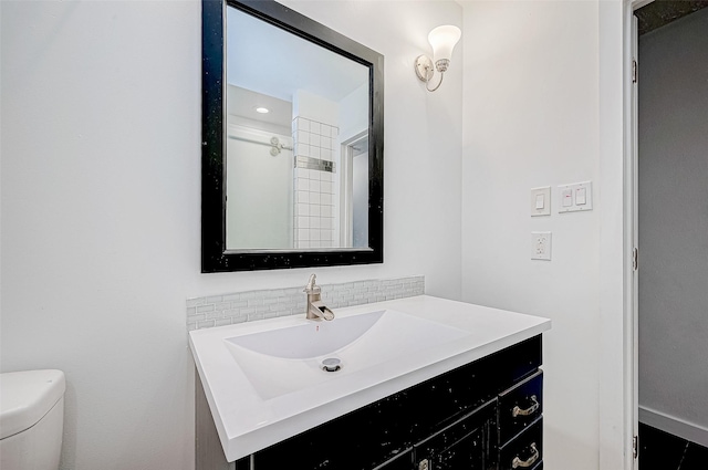 bathroom with decorative backsplash, vanity, and toilet