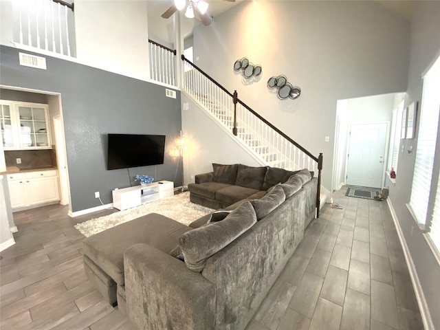 living room with ceiling fan and a high ceiling