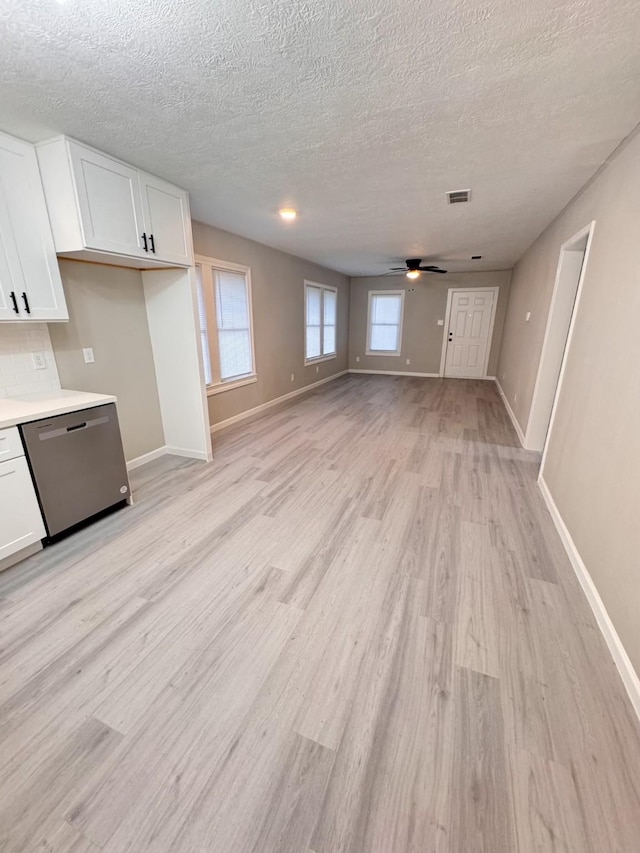 unfurnished living room featuring ceiling fan, light hardwood / wood-style flooring, and a textured ceiling