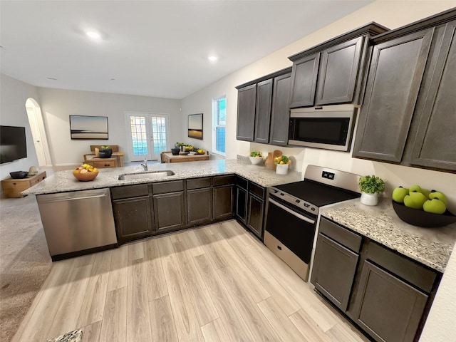 kitchen featuring kitchen peninsula, sink, stainless steel appliances, and light hardwood / wood-style flooring