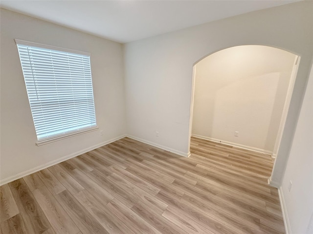 empty room with plenty of natural light and light hardwood / wood-style floors