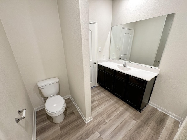 bathroom featuring hardwood / wood-style flooring, vanity, and toilet