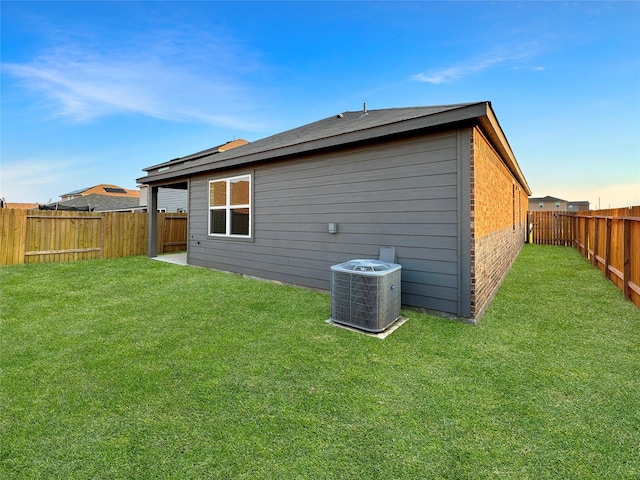 back of house featuring a lawn and central AC