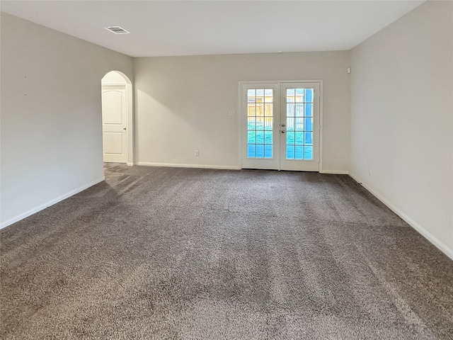 spare room with french doors and dark carpet