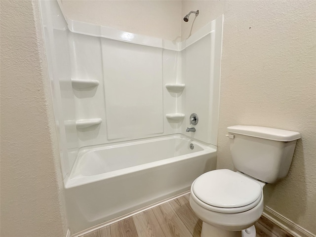 bathroom featuring wood-type flooring, toilet, and shower / bathtub combination