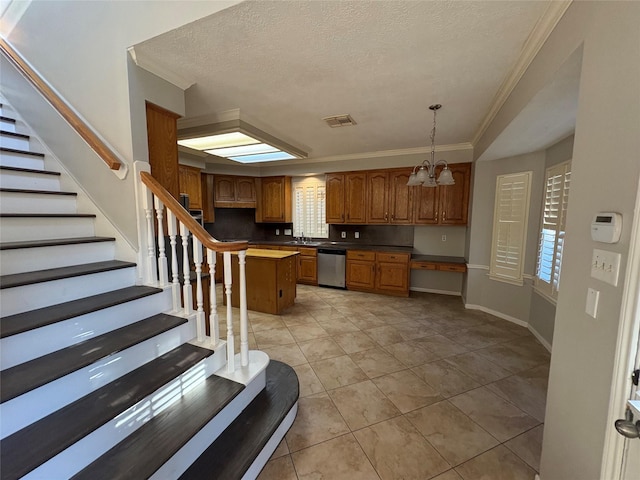 kitchen featuring crown molding, pendant lighting, dishwasher, a center island, and a chandelier