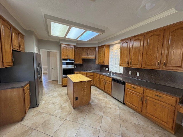 kitchen featuring crown molding, tasteful backsplash, butcher block countertops, a kitchen island, and stainless steel appliances