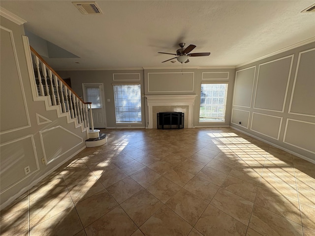 unfurnished living room with ceiling fan, light tile patterned floors, and ornamental molding