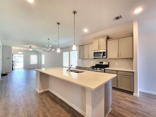 kitchen featuring appliances with stainless steel finishes, gray cabinetry, ceiling fan, sink, and an island with sink