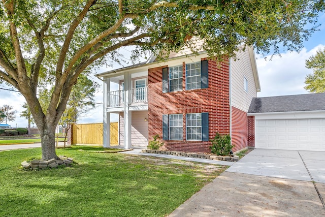 view of front of home featuring a garage, a balcony, and a front yard