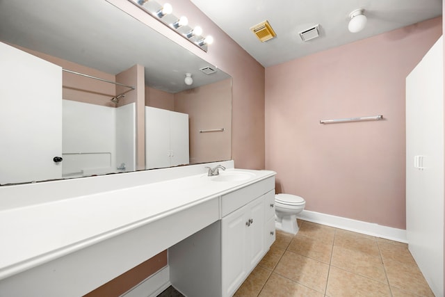 bathroom featuring tile patterned floors, vanity, toilet, and walk in shower