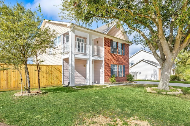 view of front of home with a front yard and a balcony