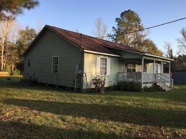 view of property exterior featuring central AC, a yard, and a porch