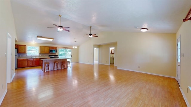 living room with light hardwood / wood-style flooring, vaulted ceiling, and sink