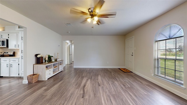 unfurnished living room with ceiling fan and light wood-type flooring