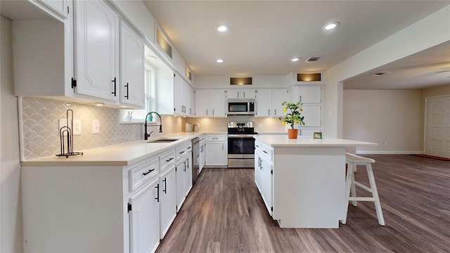 kitchen featuring white cabinetry, sink, a center island, and stainless steel appliances