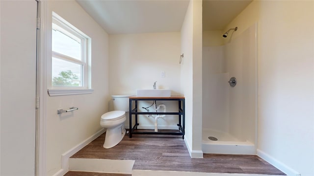 bathroom featuring hardwood / wood-style floors, toilet, walk in shower, and sink