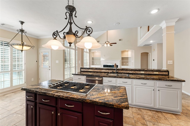 kitchen with white cabinets, sink, a center island, and decorative light fixtures