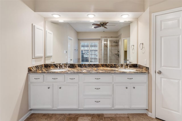 bathroom with ceiling fan, a shower with shower door, and vanity