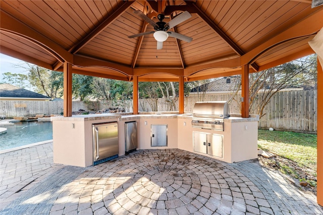 view of patio featuring area for grilling, ceiling fan, and an outdoor kitchen