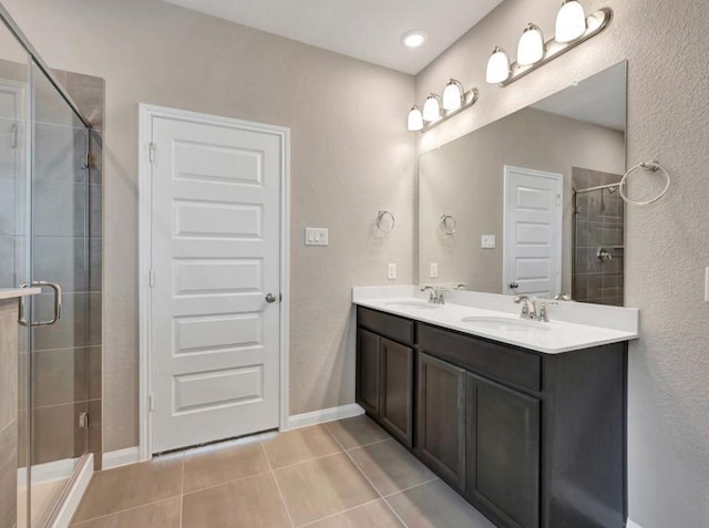 bathroom featuring tile patterned flooring, vanity, and a shower with shower door