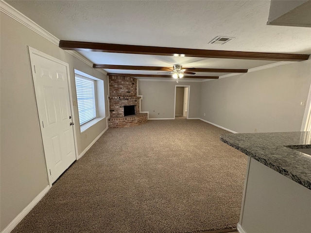 unfurnished living room featuring carpet, ceiling fan, ornamental molding, a fireplace, and beam ceiling