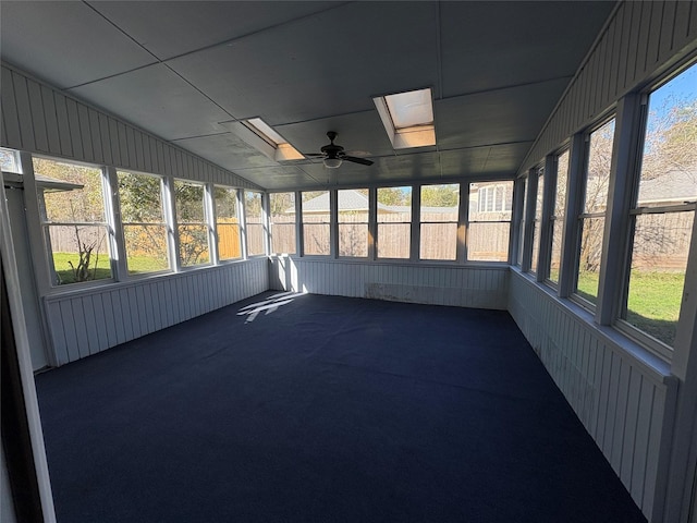 unfurnished sunroom with ceiling fan and lofted ceiling with skylight