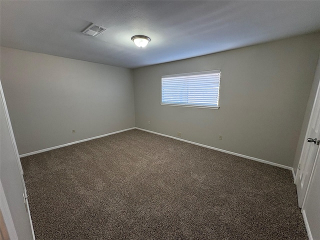 empty room featuring dark carpet