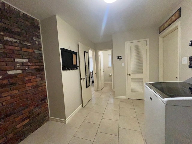 clothes washing area featuring washer / clothes dryer and light tile patterned flooring