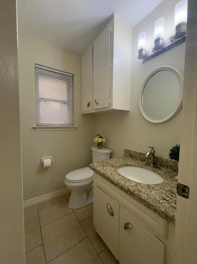 bathroom with toilet, tile patterned flooring, and vanity