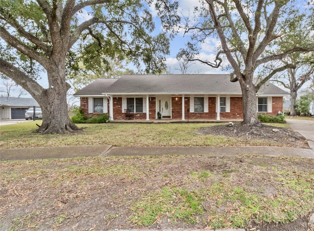 ranch-style home with a front yard and covered porch