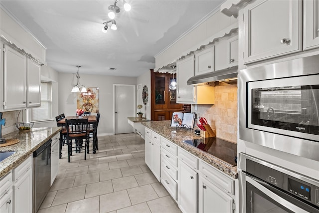 kitchen with stainless steel appliances, white cabinetry, tasteful backsplash, and light stone counters