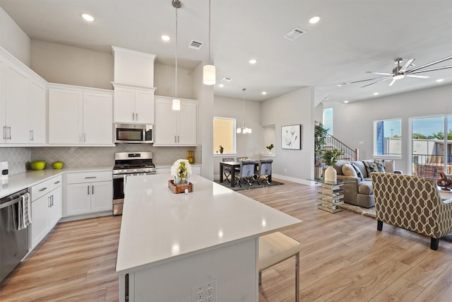 1956 Purswell Rd, Houston, TX 77055 - kitchen with appliances with stainless steel finishes, light wood-style flooring, a center island, light countertops, and recessed lighting