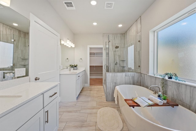1956 Purswell Rd, Houston, TX 77055 - bathroom with a shower stall, two vanities, a spacious closet, a freestanding bath, and recessed lighting