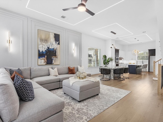 living room with hardwood / wood-style floors and ceiling fan