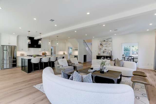 living room with beamed ceiling and light hardwood / wood-style flooring