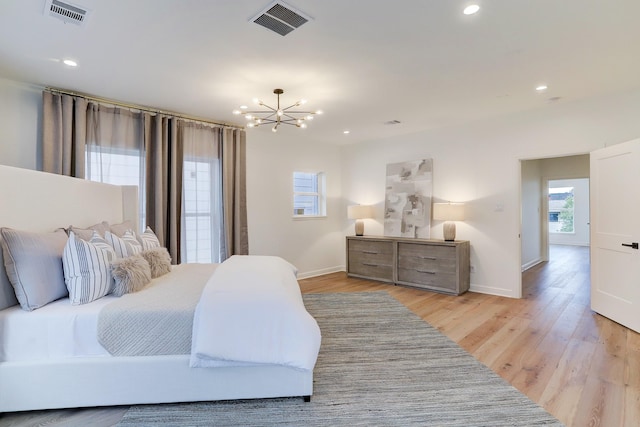 bedroom with light hardwood / wood-style flooring and a notable chandelier