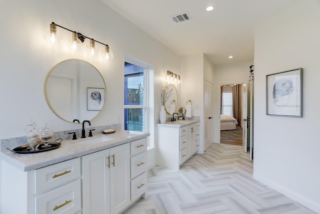 bathroom with parquet flooring, vanity, and a wealth of natural light