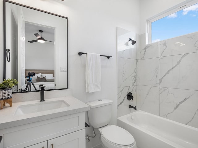 full bathroom featuring vanity, toilet, tiled shower / bath, and ceiling fan